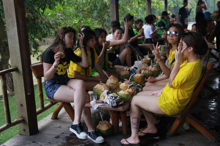 Peserta menikmati kelapa muda sambil bersantai setelah kegiatan rafting di Sungai Citarik Sukabumi