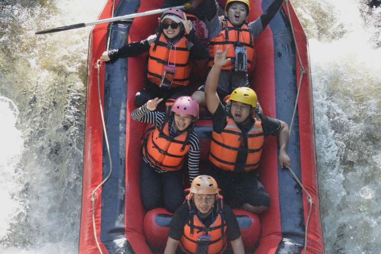 Satu tim wisatawan kompak mendayung perahu karet saat arung jeram di Palayangan Pangalengan